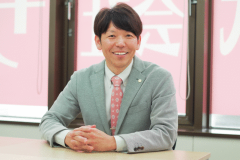 岩田代表（笑顔・机）